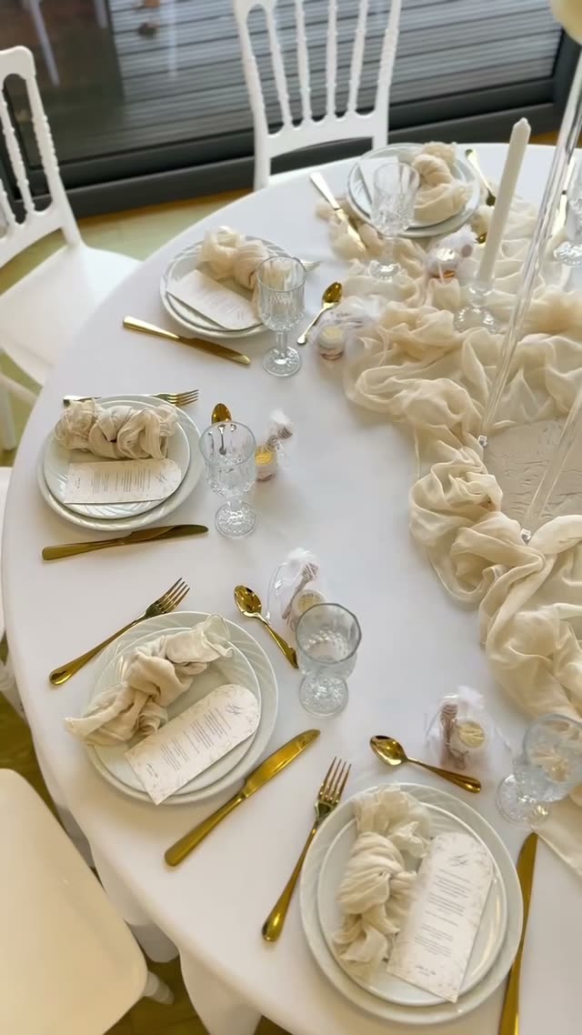 Table ronde, serviettes ivoire et couverts dorés